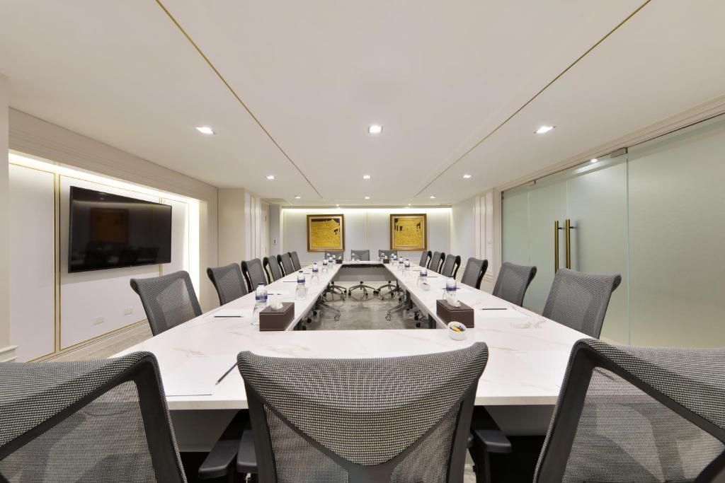 A formal conference room with a long boardroom table and executive chairs.