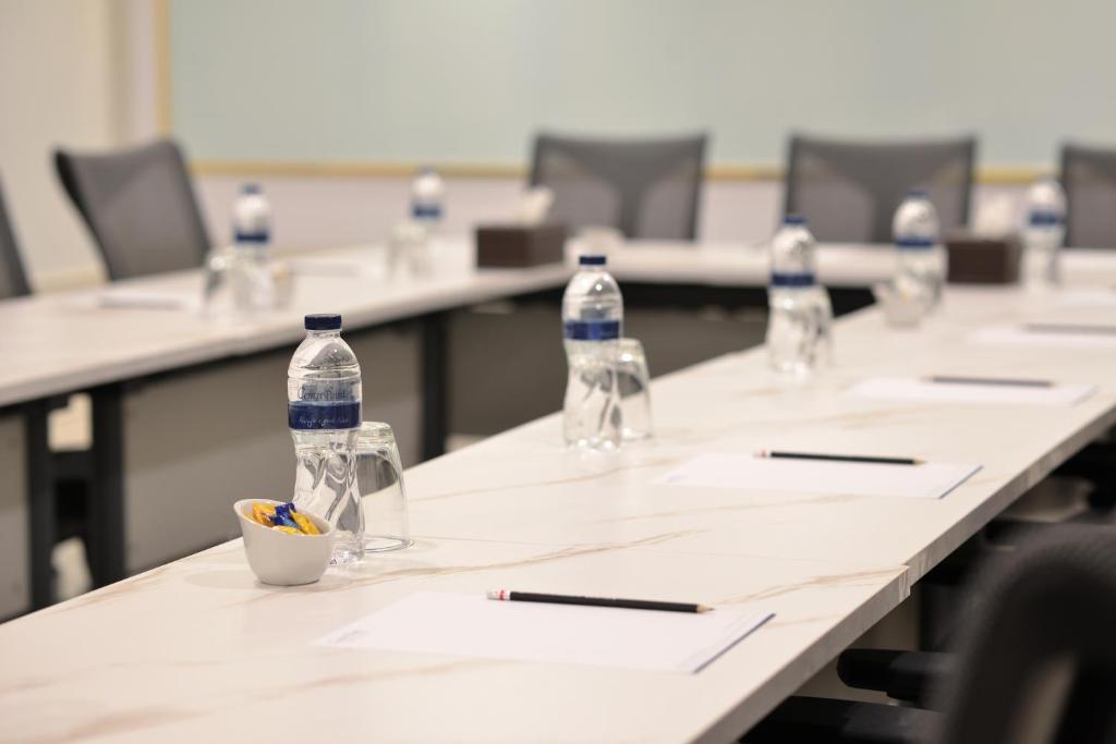 A prepared conference-room layout with bottled water, glasses, notepads and pens.