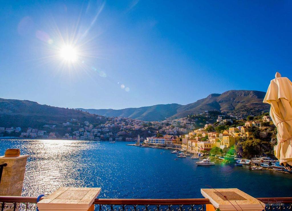 a view of a town and a lake with an umbrella at Kleanthi and Kostas Studios in Symi