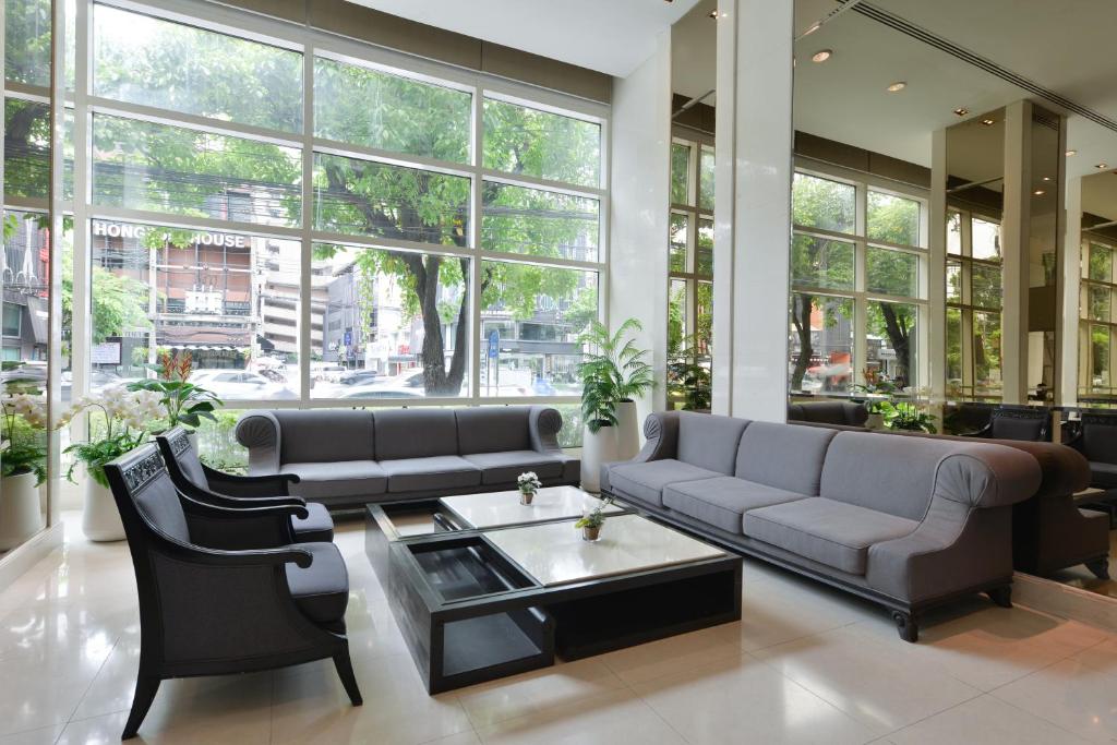 A spacious sitting area with sofas, armchairs and a street-facing window wall.