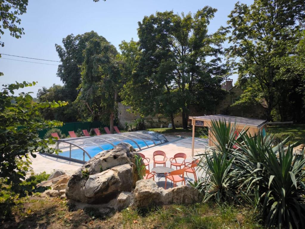 a swimming pool with chairs and a rock at Lou Cantou sur Lunain in Paley