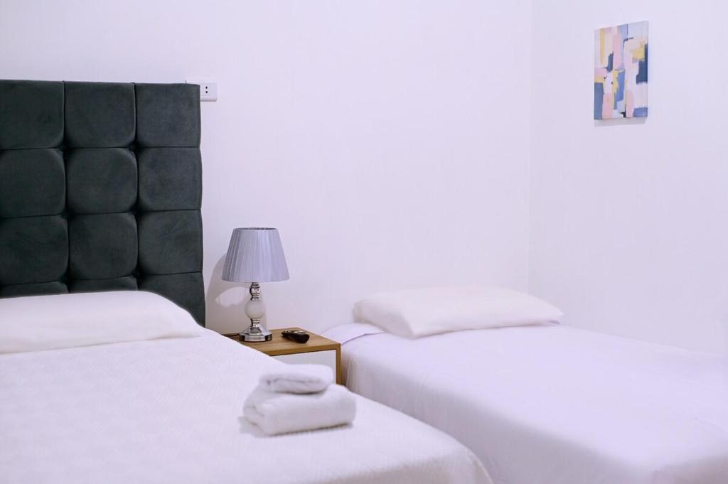 ein Schlafzimmer mit 2 Betten und einer Lampe auf einem Nachttisch in der Unterkunft Modern Flat in Lince - 2 bedrooms in Lima