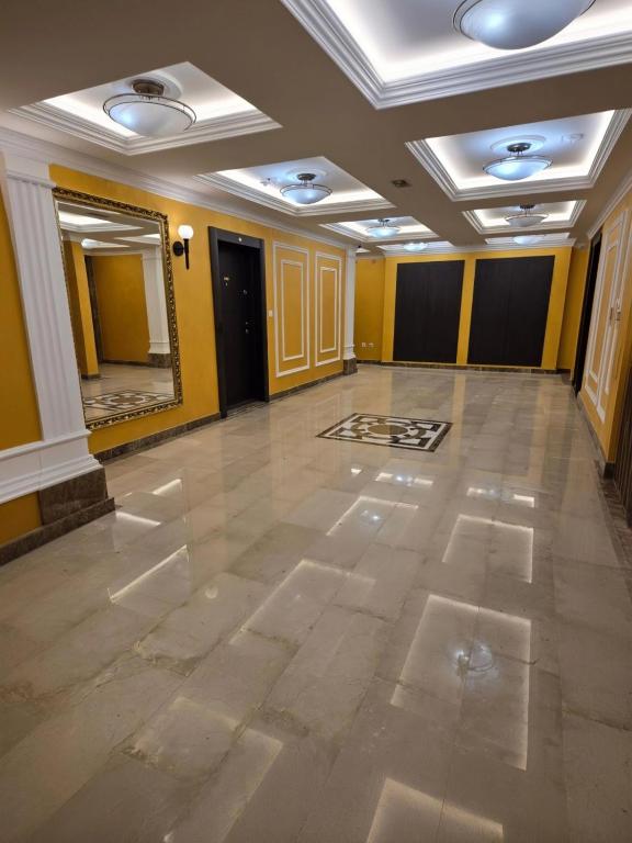 an empty room with yellow walls and a large mirror at Central Lux in Čačak