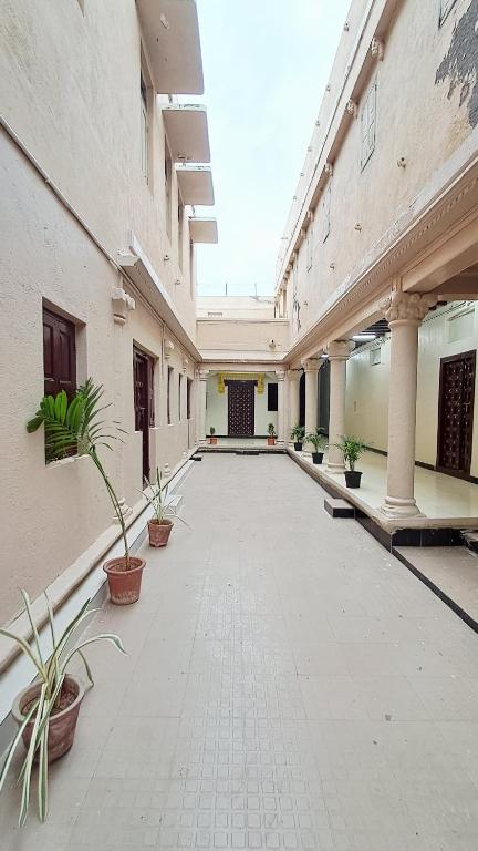 an empty courtyard with potted plants in a building at The Imperial Regency in Porbandar