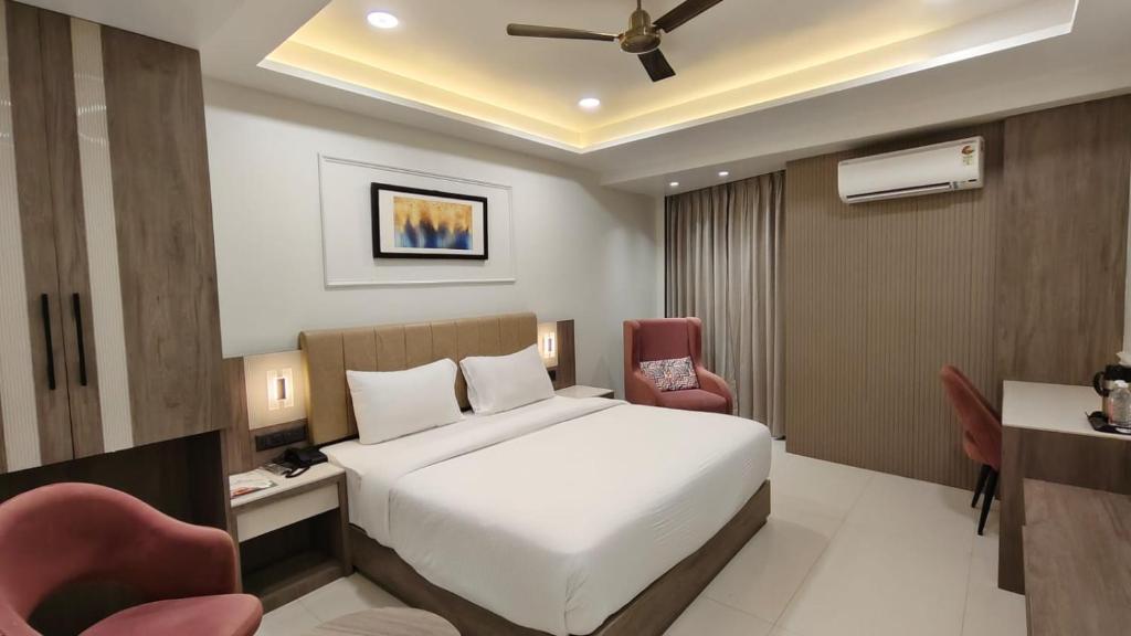 a hotel room with a bed and two chairs at Park View in Varanasi