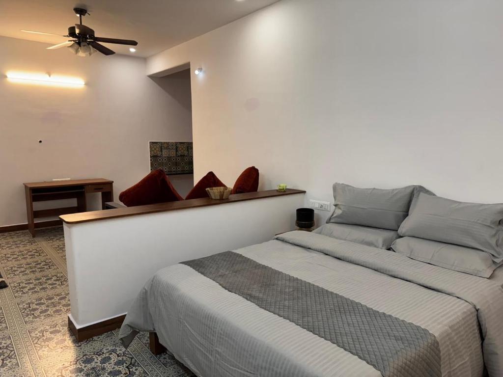 a bedroom with a bed and a ceiling fan at Phalguni Farm Stay in Nanjangūd