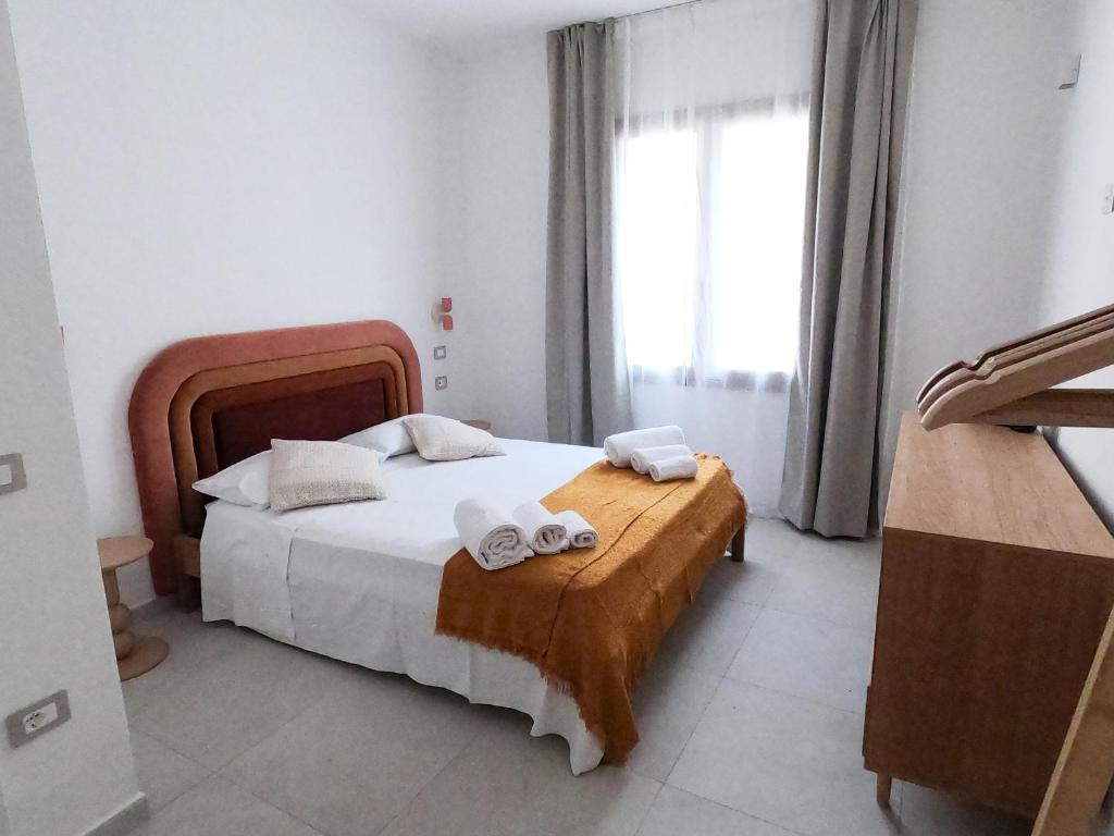 a bedroom with a bed with towels on it at Luxi Apartment Teulada in Teulada