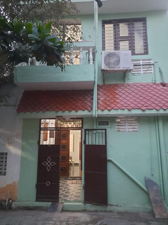 uma casa com duas portas e um telhado vermelho em Sai Home Stay em Pondicherry