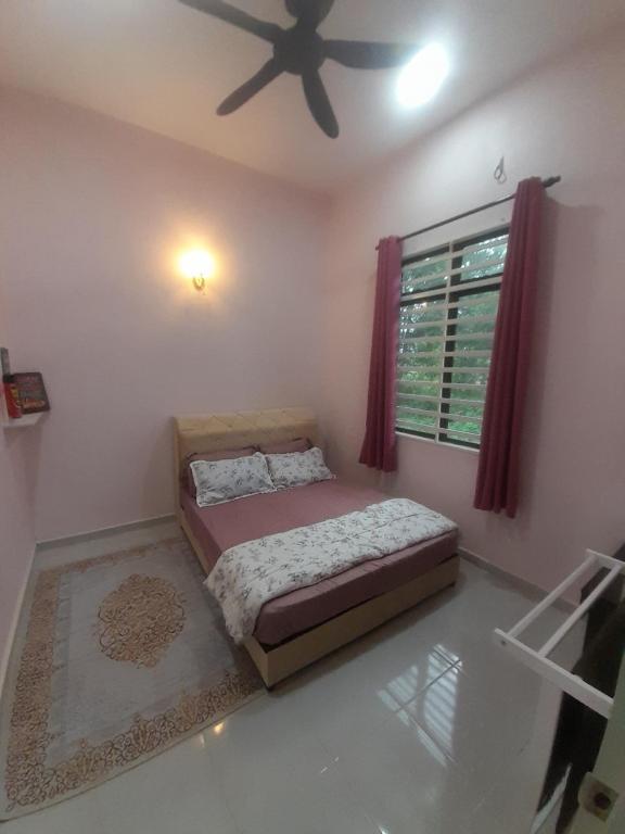 a bedroom with a bed and a ceiling fan at Marissa Homestay 