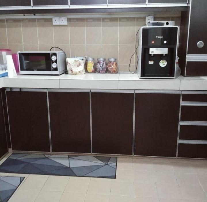 a kitchen counter with a microwave and a toaster oven at 4-room double storey house, 10km KLIA in Sepang