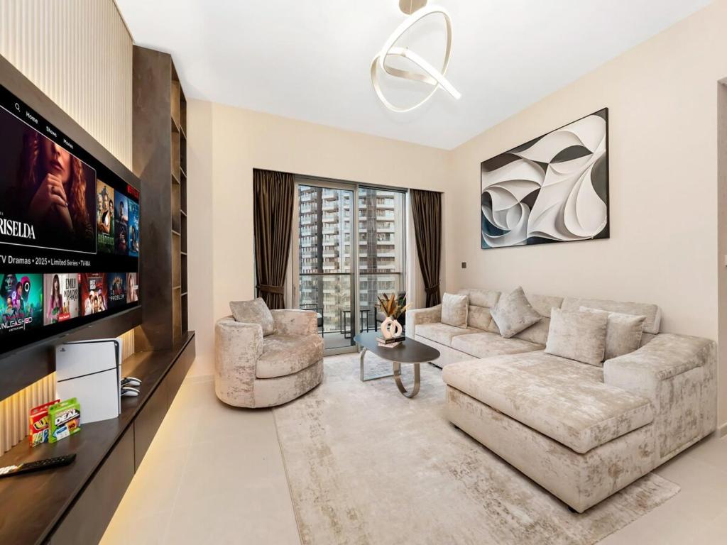 Una sala de estar con un sofá y un televisor. en Skyline View - 2 Balconies - Pool plus Gym - Sleeps 8, en Dubái