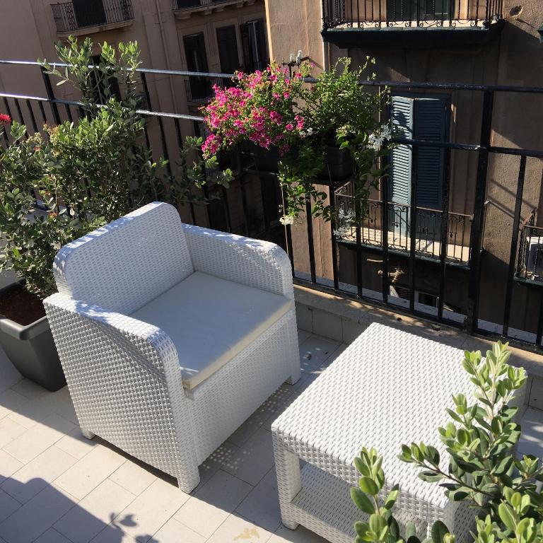 a wicker chair and a table on a balcony at Dimora Villareale in Palermo
