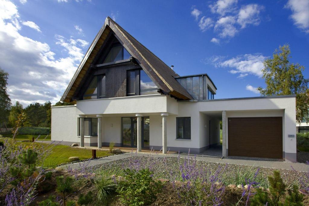 ein weißes Haus mit einem Walmdach in der Unterkunft Kapitänsweg 17 in Ostseebad Karlshagen