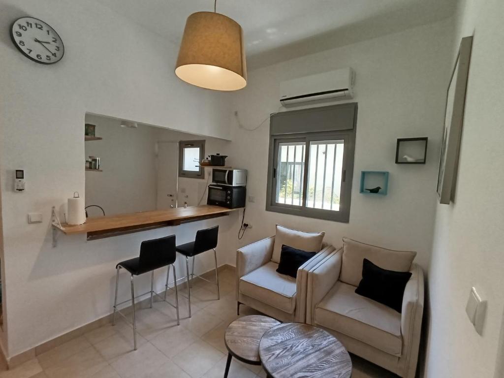 a living room with a couch and a kitchen with a counter at My Lovely Apt in Tel Aviv