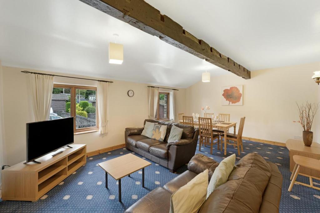 a living room with a couch and a tv at Bank View Barn at Pound Farm in Crook