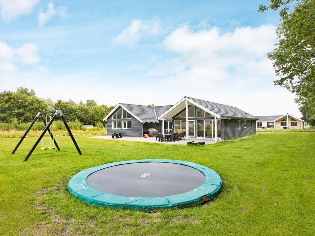 a small house with a trampoline in the yard at 16 person holiday home in Glesborg in Fjellerup Strand