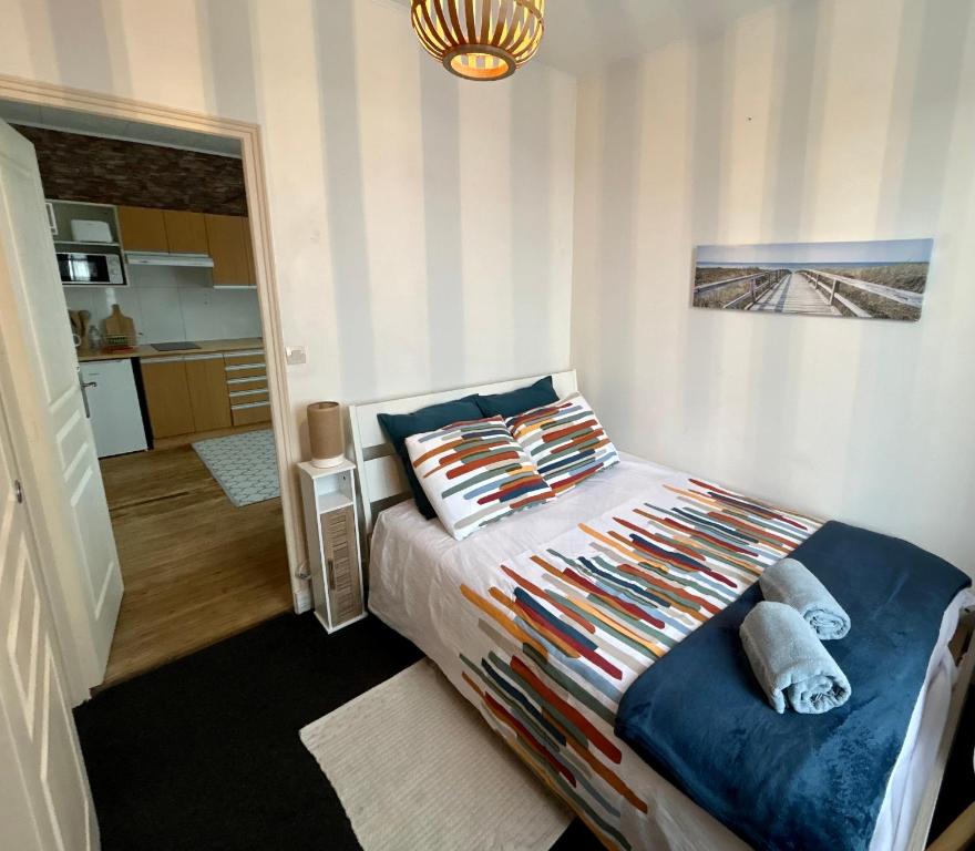 a bedroom with a bed with a blue comforter at Mer & Côte Fleurie Plage à pied in Merville-Franceville-Plage