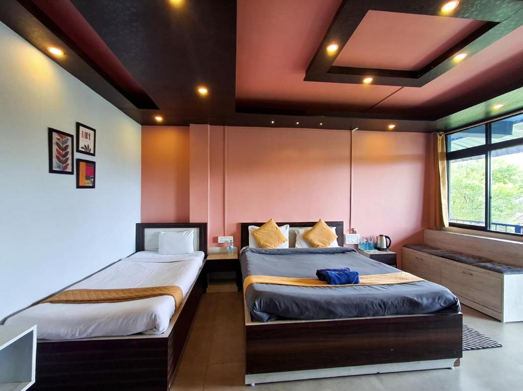 a bedroom with two beds and a desk in it at Valley View Homestay in Cherrapunji