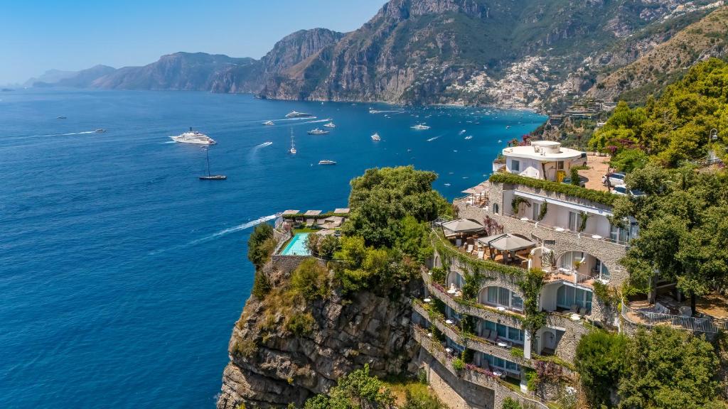 a building on a cliff next to the water at Hotel Piccolo Sant'Andrea in Praiano