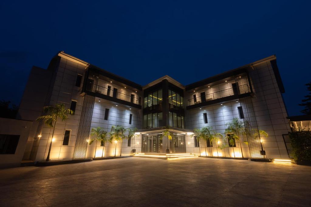 a large building with a parking lot at night at Tide` Hotels and Resorts in Abuja