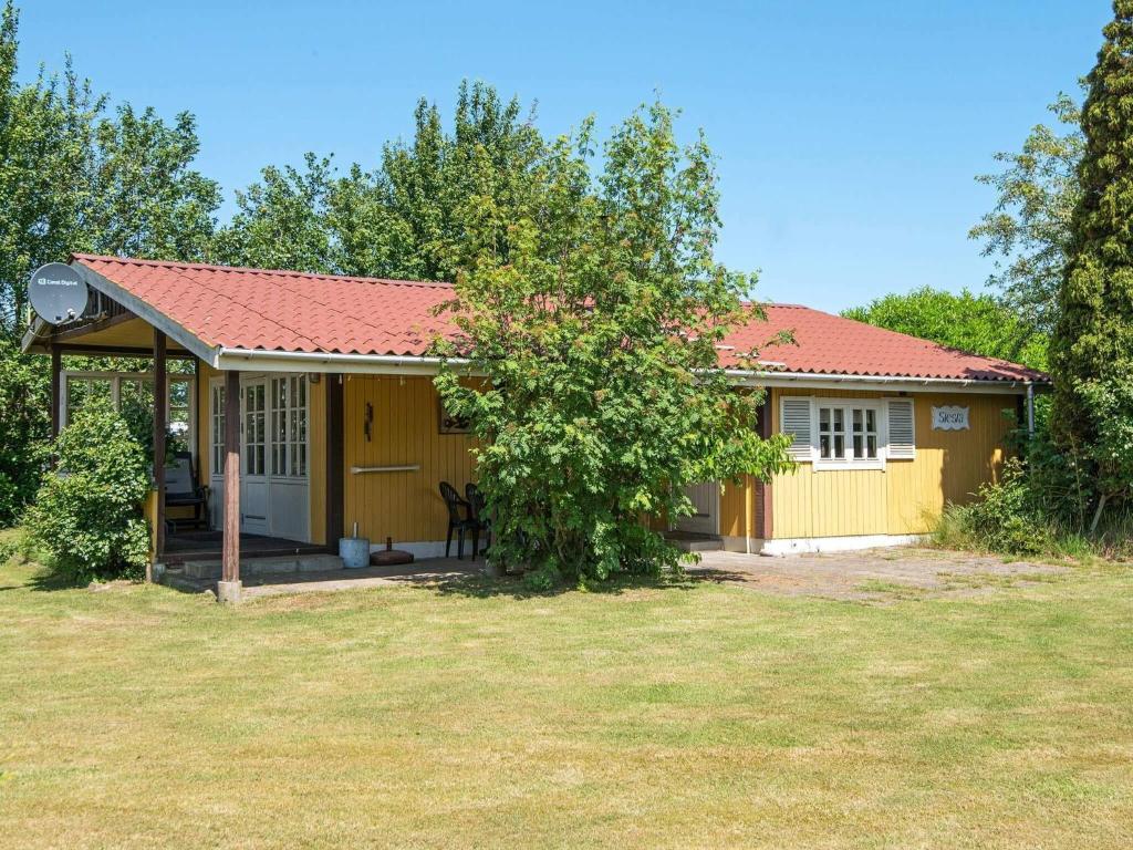 a small yellow house with a red roof at 4 person holiday home in Nordborg in Nordborg