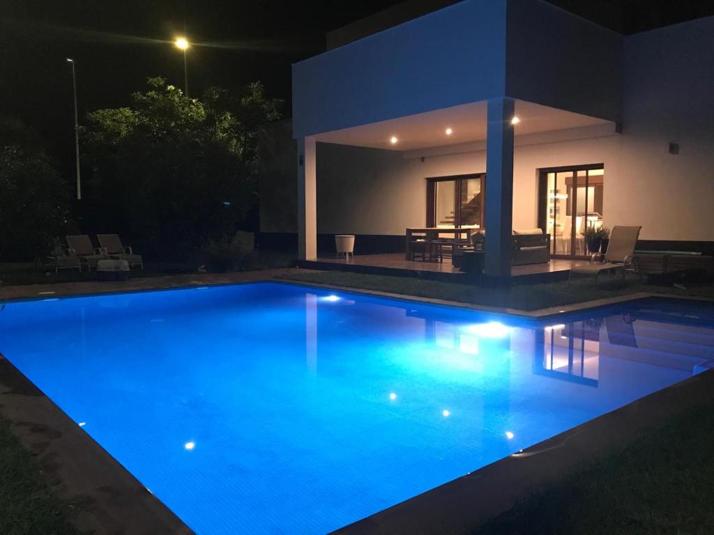 a swimming pool in front of a house at night at Villa Xauxa - Vida mediterránea in Gandía