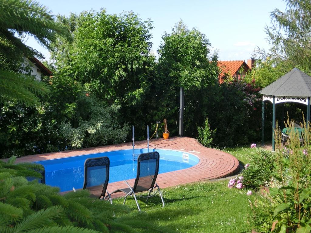 a swimming pool with two chairs and a gazebo at Gruppenunterkunft mit Pool in Ballenstedt in Ballenstedt