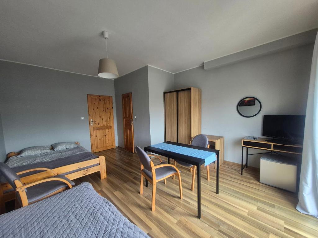 a bedroom with a bed and a table and a desk at Pokoje Gościnne Anastazja in Władysławowo