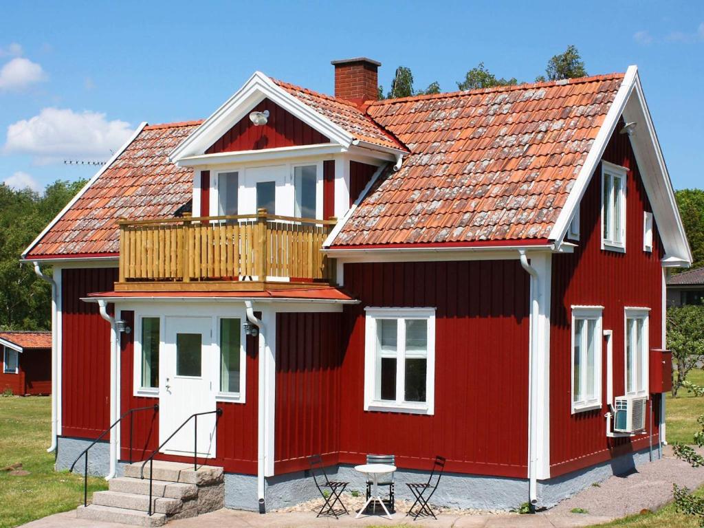 a red house with a deck on top of it at 4 star holiday home in Söderåkra in Söderåkra