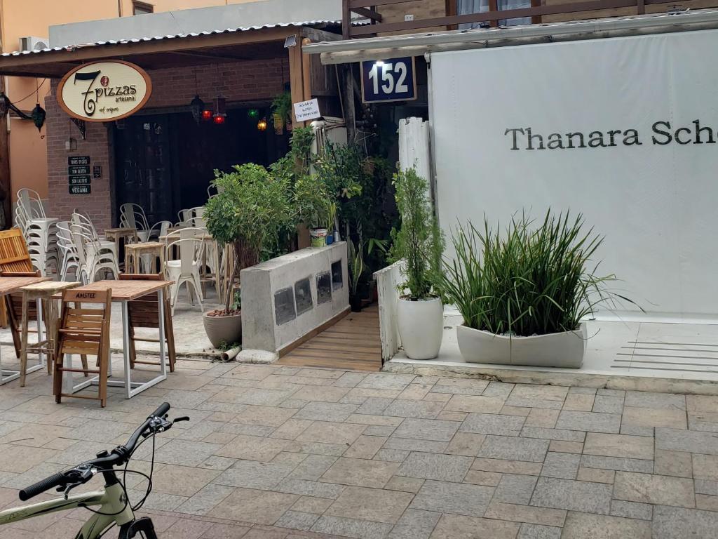 a bike parked outside of a restaurant with tables and chairs at Suítes Da Vila 152 in Praia do Forte