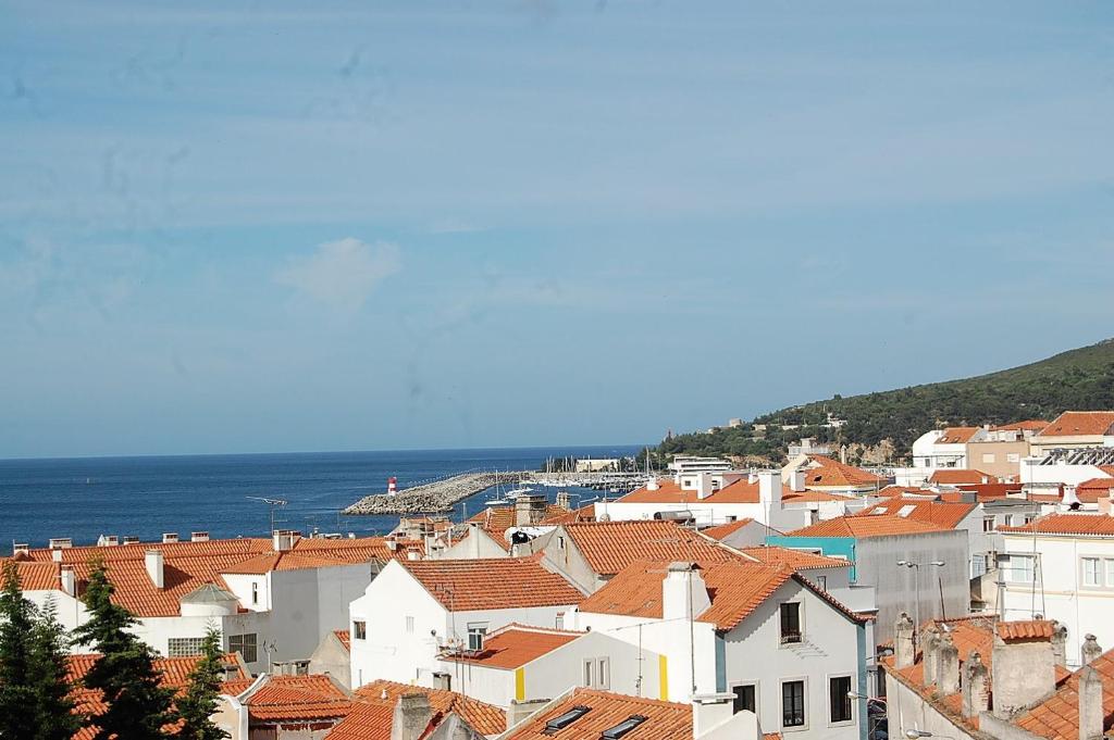 a view of a town with houses and the ocean at Casa Das Gaivotas in Sesimbra