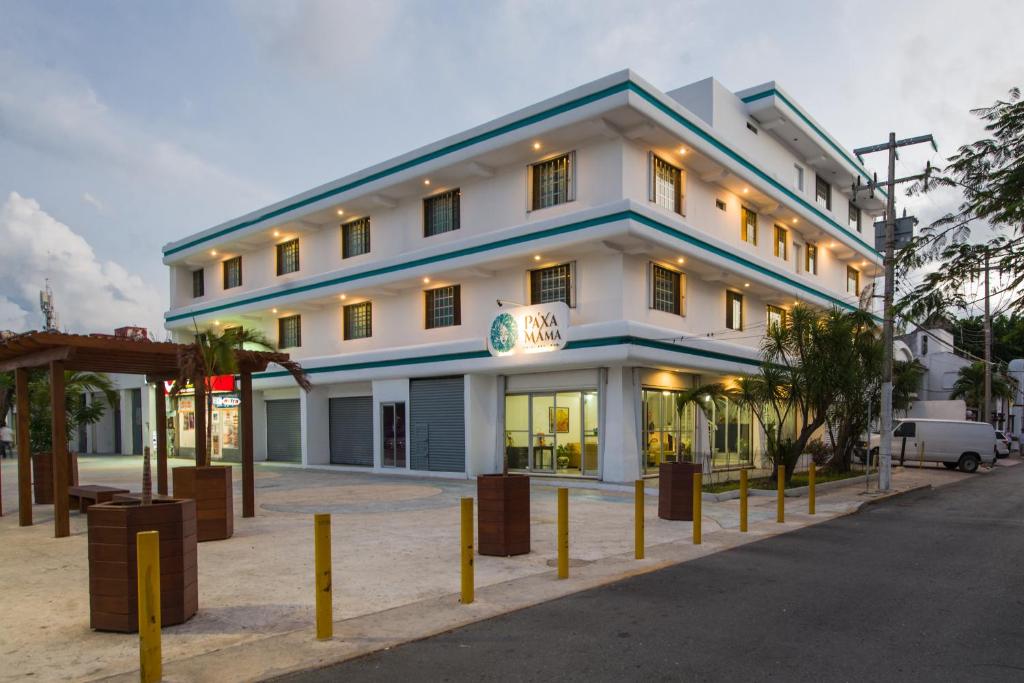 a large white building with yellow poles in front of it at Pa´Xa Mama Hotel Boutique in Cancún