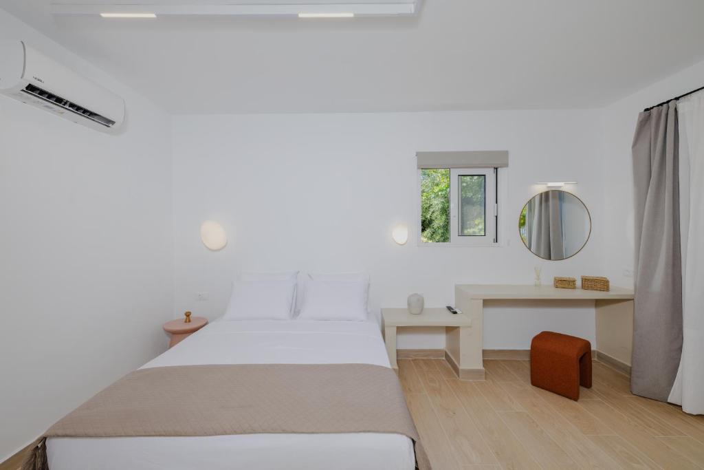 コリンビアにあるPension Zoi Luxury Roomのベッドと机のある白い寝室