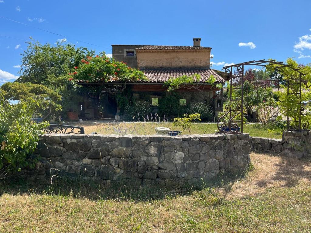 a stone wall in front of a house at Chambre d'hôtes et gîte de la la Bannette in Thoard