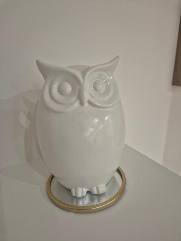a white vase with an owl face on a table at Studio Dijon centre et facultés in Dijon