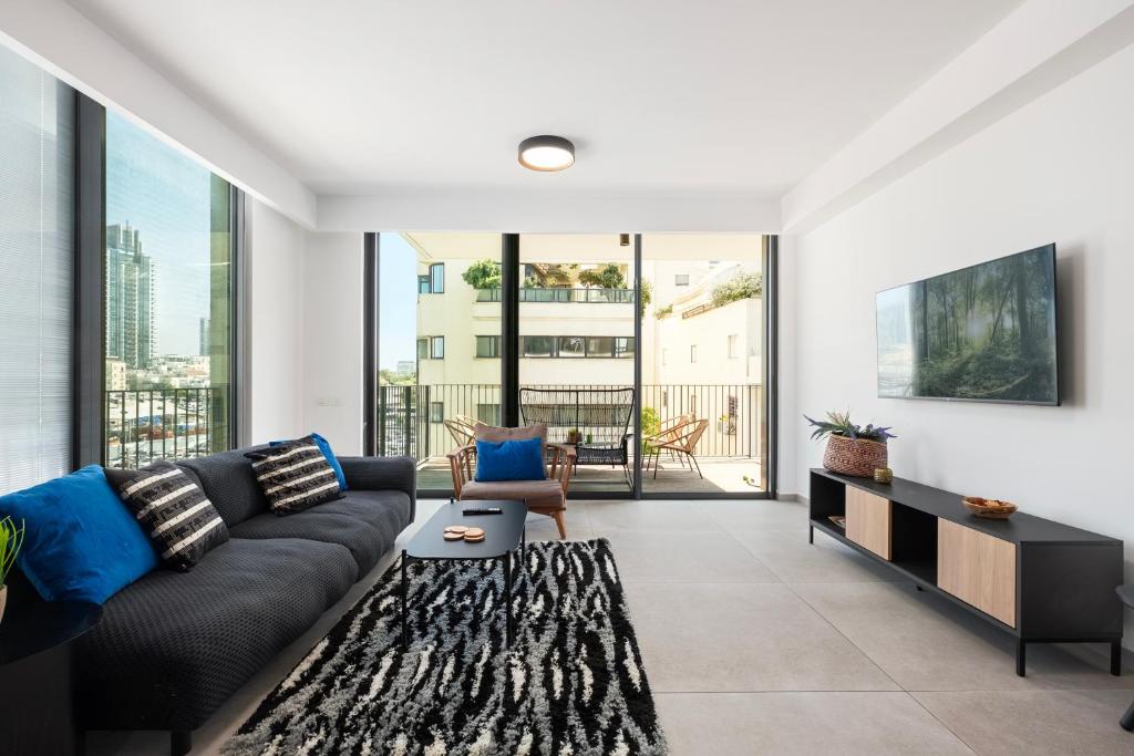 a living room with a couch and a table at Luxury 3BR Sea View and Pool in Tel Aviv