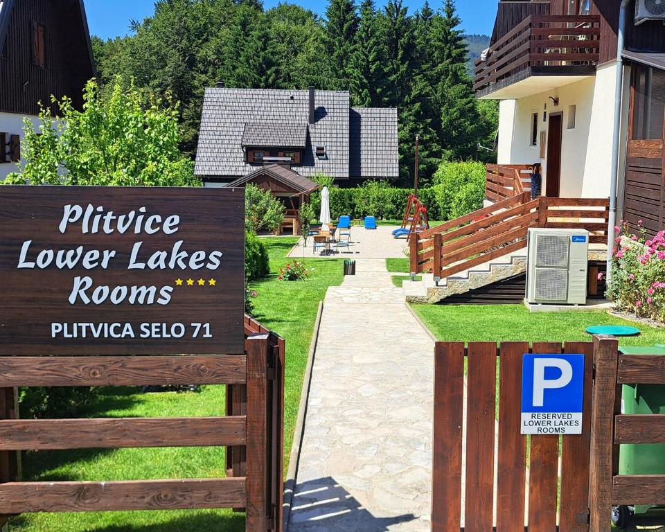 a sign in front of a yard with a house at Plitvice Lower Lakes Rooms in Plitvica Selo