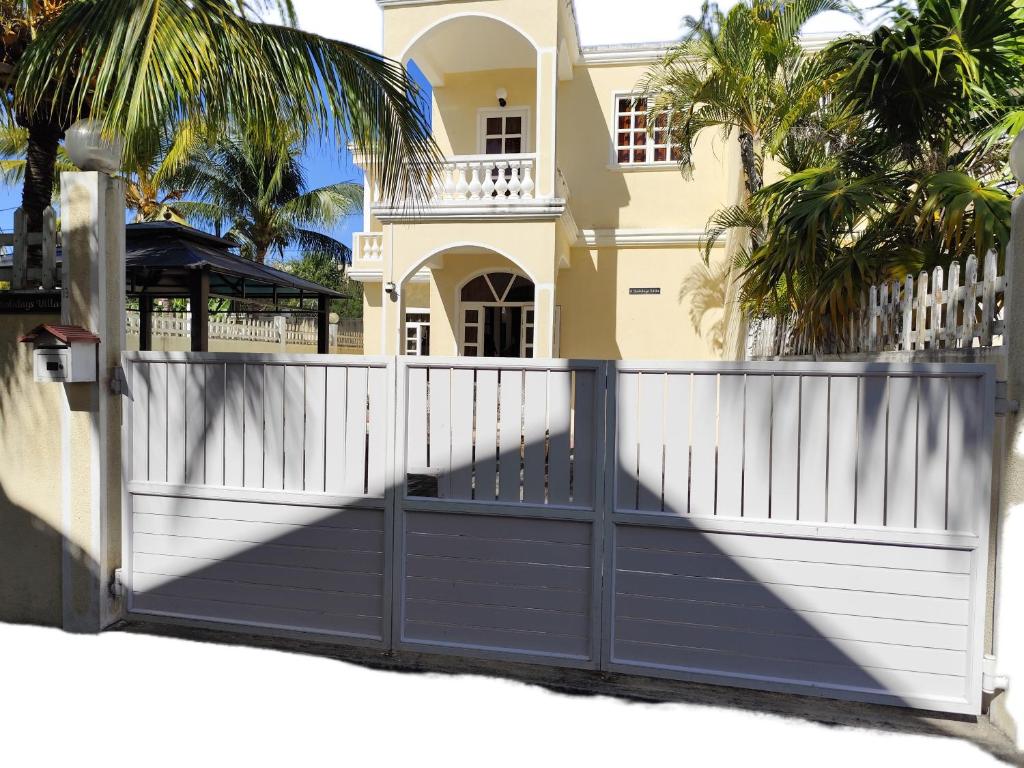 una recinzione di fronte a una casa con palme di EHolidays Villa a Pereybere