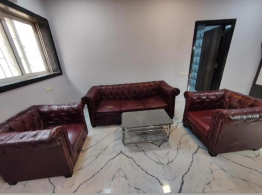 sala de estar con sofás de cuero y espejo en Zi villa, en Bombay