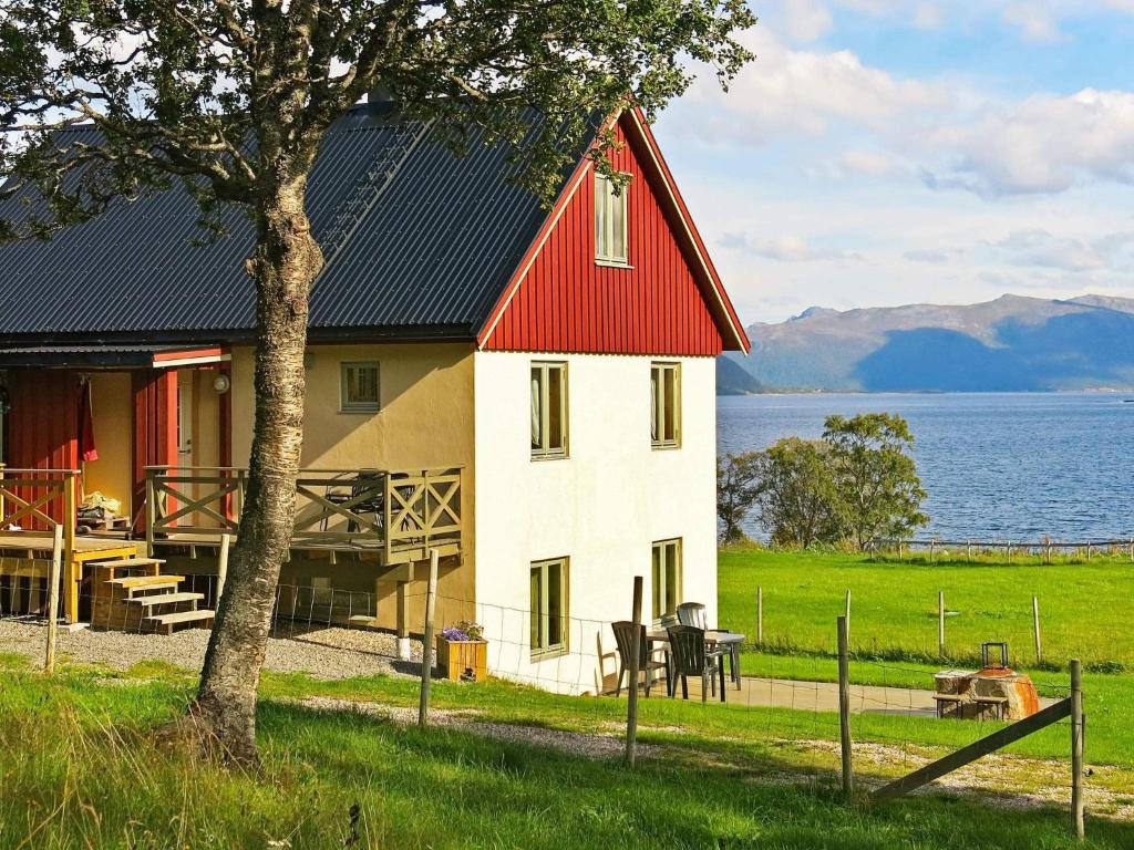una casa con techo rojo junto al agua en 6 person holiday home in ALSVÅG-By Traum, en Gisløy