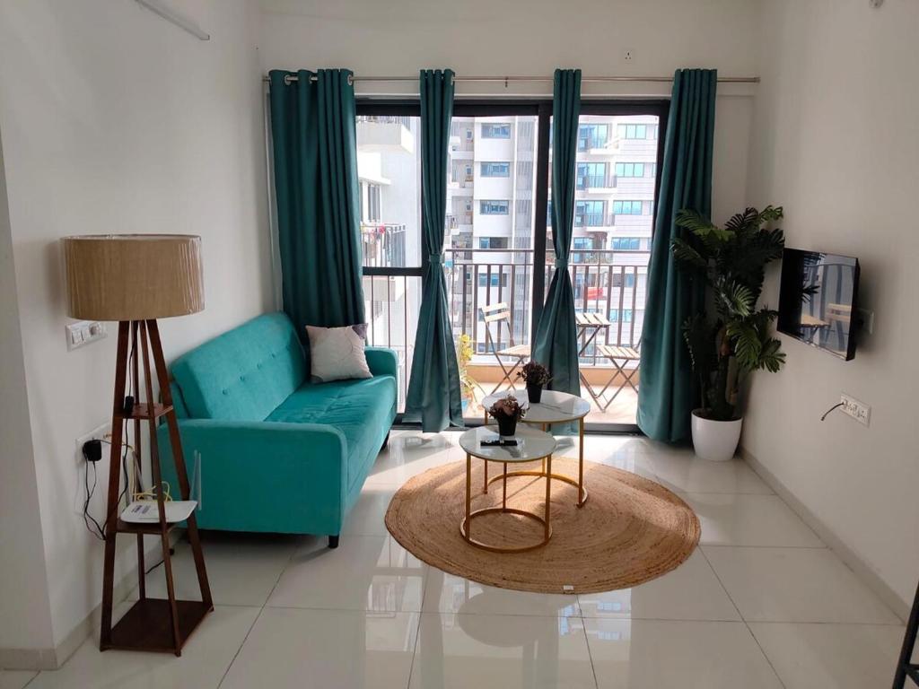a living room with a blue couch and a table at AquaPrivate 1Bhk Apartment in Amanora Park Town in Pune