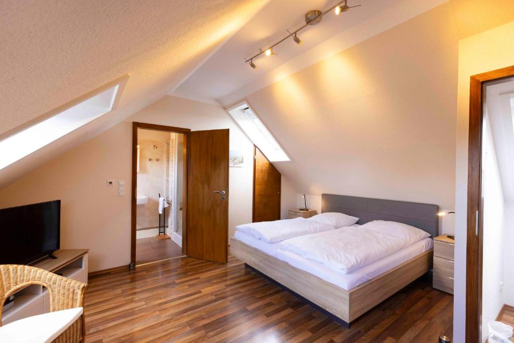 a bedroom with a large bed and a television at MEI27a Ferienwohnung Ostseetraum in Niendorf