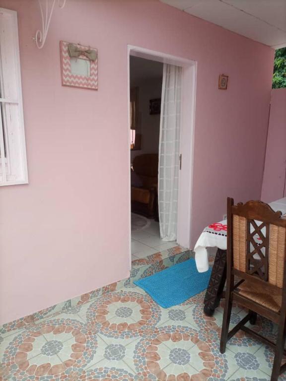 a room with a pink wall and a tile floor at La myrtille de Liesse in Nzamata