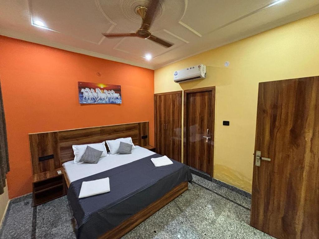 una camera da letto con un letto con una parete arancione di Voyageurs Homestay ad Agra