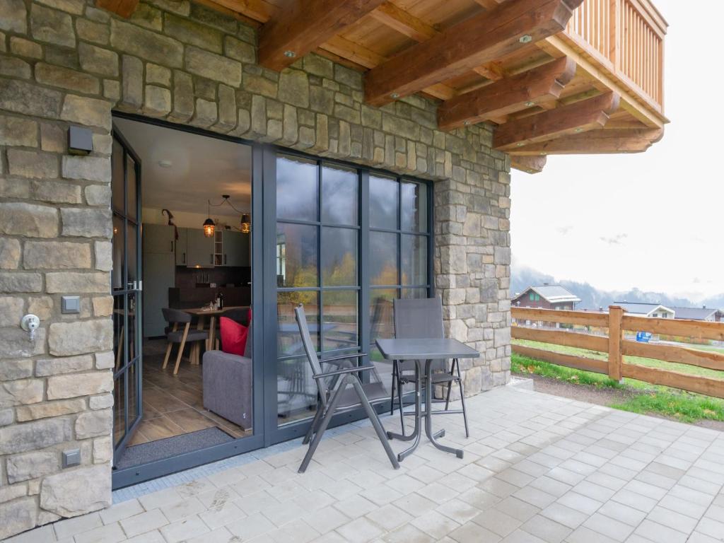 a patio with glass doors and a table and chairs at Chalet in Krimml near Ski Slopes in Krimml