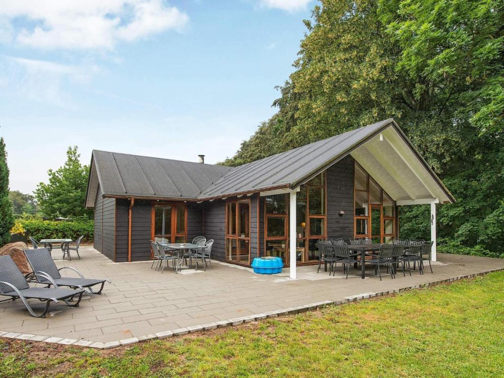 una casa con tetto spiovente con tavoli e sedie di Cozy Retreat in Lojtland - By Traum Ferienwohnungen a Aabenraa