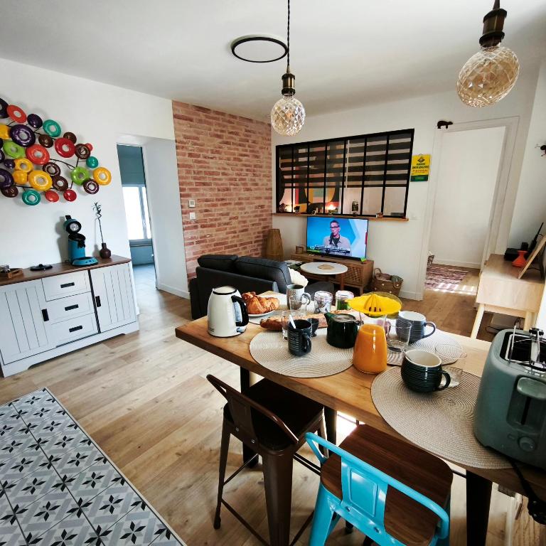 a kitchen and living room with a table and chairs at Maison Sorbier, Appartement 1 in Nevers