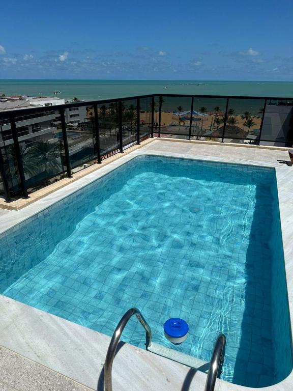ein Swimmingpool mit Blick auf das Meer in der Unterkunft Home service cabo branco varanda vista parcial in João Pessoa