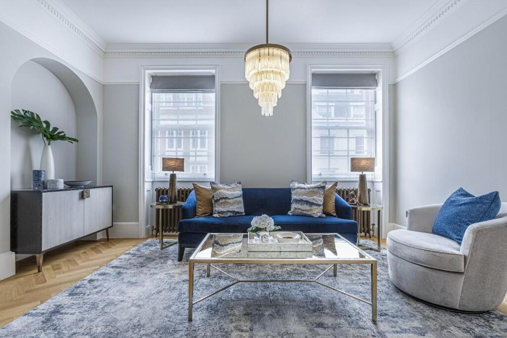 a living room with a blue couch and a table at Super Lux 3 Bed Apartment by Mayfair in London