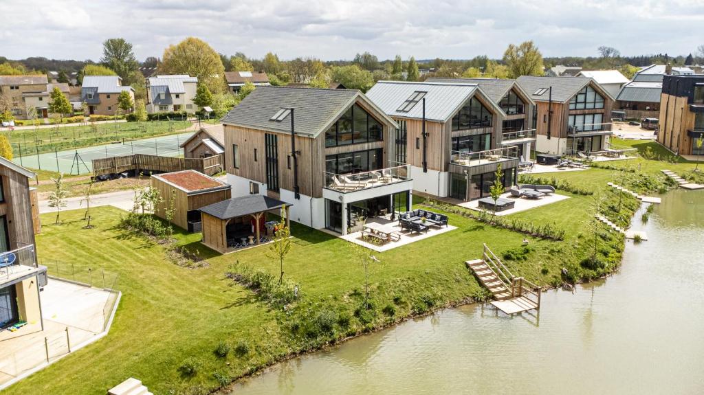 an aerial view of a row of houses next to a river at Minety Lake 07 Lower Mill Estate The Cotswolds in Somerford Keynes